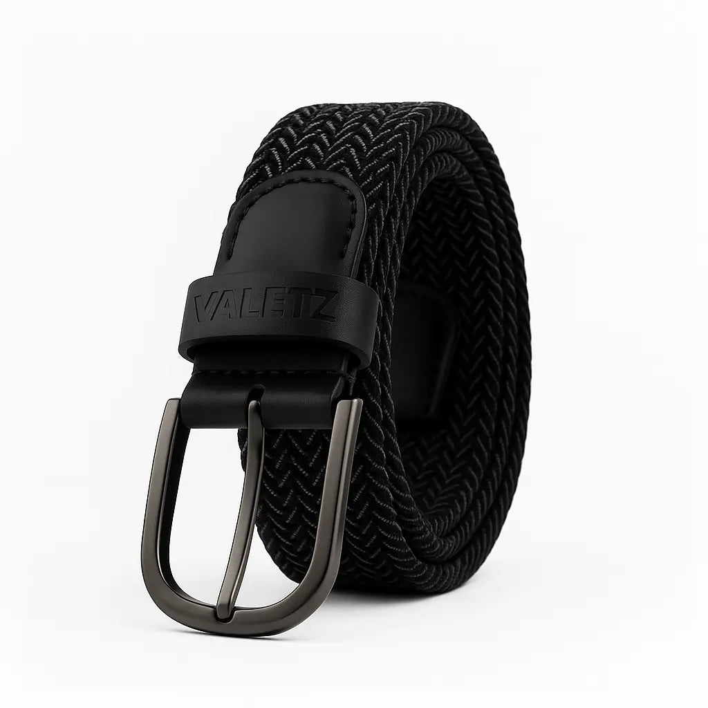 Cinturón trenzado elástico para hombre color negro y gris con terminaciones de cuero y hebilla metálica.
